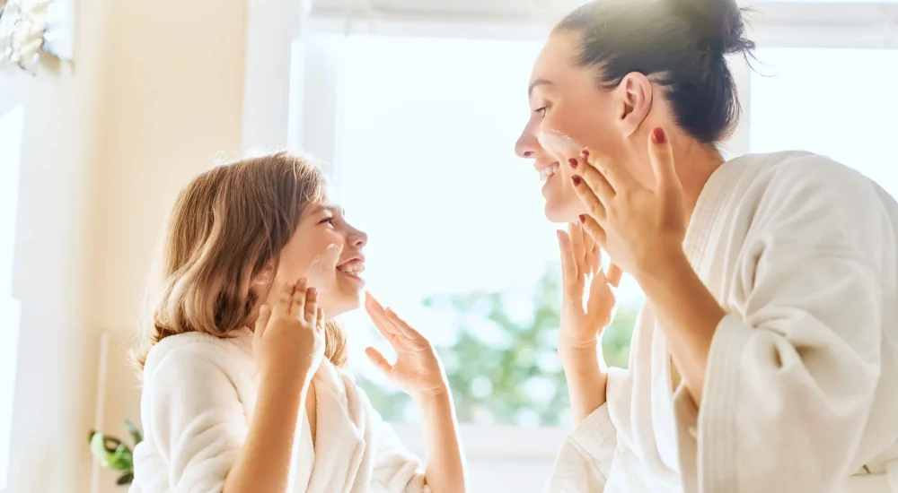 main Mother and daughter caring for skin