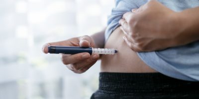 Woman is making insulin injection in the stomach. Stock photo